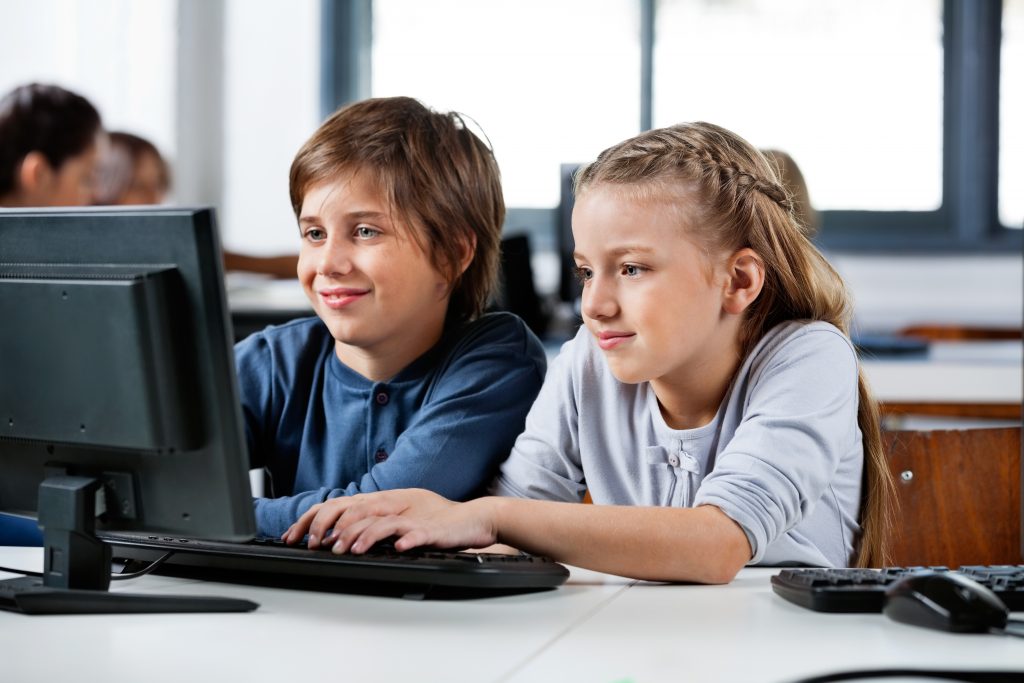 Boy And Girl Using Desktop Pc In School Computer Lab