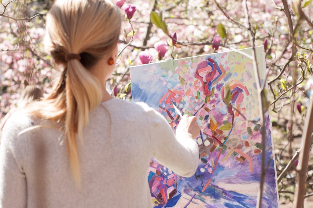 Image of a woman painting on an easel